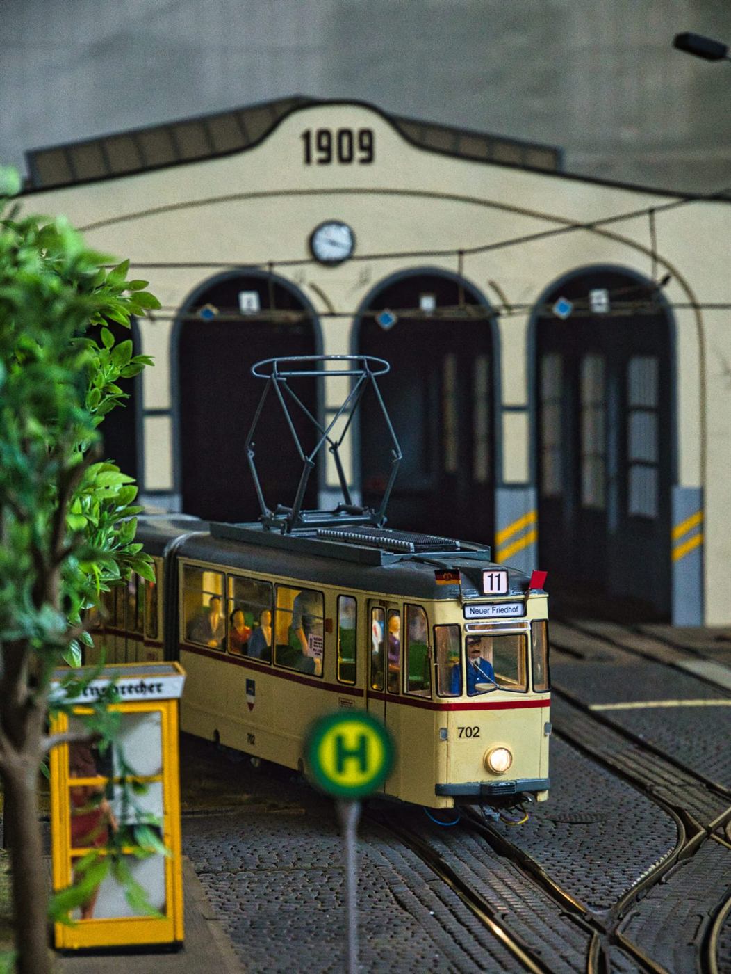 Modell-Straßenbahn vor dem nachgebauten Depot von 1909